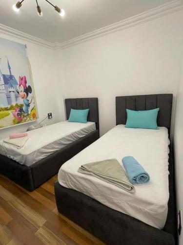 two twin beds in a room with a painting at luxury apartment at Obour, 5th floor no elevator in Cairo