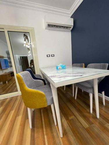 a dining room table with two chairs and a mirror at luxury apartment at Obour, 5th floor no elevator in Cairo