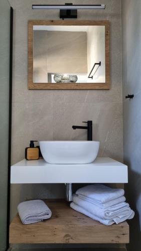 een badkamer met een witte wastafel en een spiegel bij Averof Downtown Luxury Apartment in Ioannina