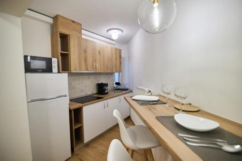 a kitchen with a white refrigerator and a table with chairs at ChECk apartment in Focşani