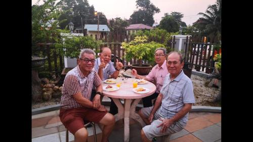 a group of older men sitting around a table at Bonsai Homestay Kluang - B17 in Kluang