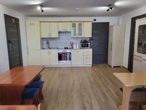 cocina con armarios blancos y mesa de madera en Apartamenty na Lipowej, en Sandomierz