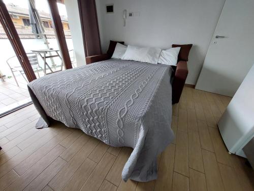 a bedroom with a bed with a white comforter at Pizzocolo resort fasano in Gardone Riviera