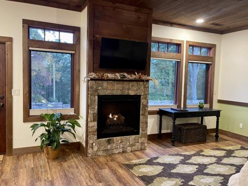 sala de estar con chimenea y TV de pantalla plana en The Dogwood Inn, en Blue Ridge