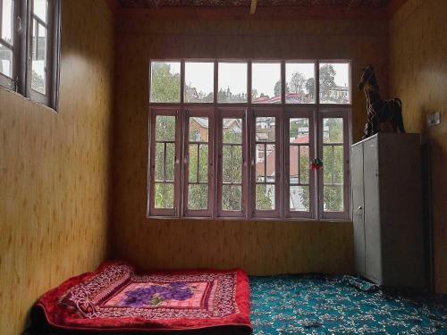 a room with a bed in front of a window at POP Nafia Homestay in Bhadarwāh