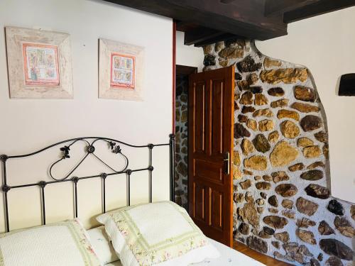 a bedroom with a bed and a stone wall at Casa Diego in Las Rozas