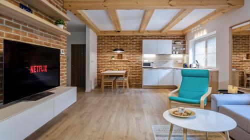 a living room with a large tv and a kitchen at Apartmán Vrátna in Terchová