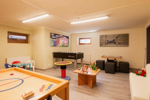 a living room with a pool table and a piano at Falkner Appartement Resort in Längenfeld