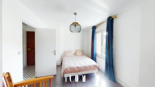 une chambre avec un lit et une fenêtre dans l'établissement Appartement cosy d'Auge, à Caen