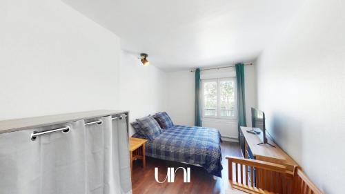 Cette chambre comprend un lit et une télévision. dans l'établissement Appartement cosy d'Auge, à Caen