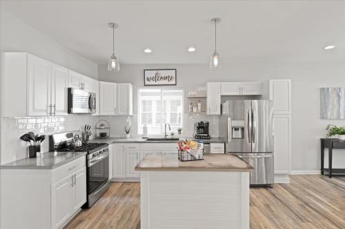 a kitchen with white cabinets and stainless steel appliances at Mapleton - Workfriendly, football table, yard, free parking in Indianapolis