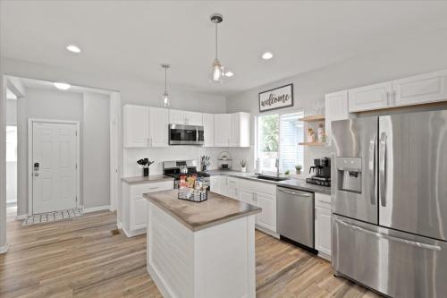 a kitchen with white cabinets and stainless steel appliances at Mapleton - Workfriendly, football table, yard, free parking in Indianapolis