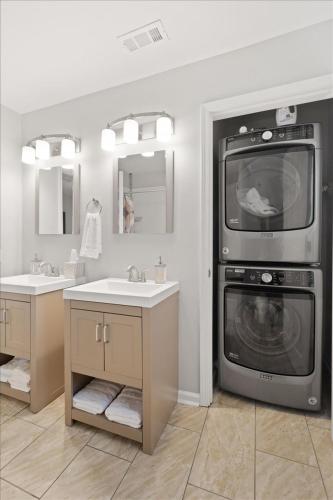 a bathroom with two sinks and a washing machine at Mapleton - Workfriendly, football table, yard, free parking in Indianapolis