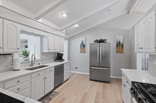 a kitchen with white cabinets and a stainless steel refrigerator at Work-friendly & near downtown in Jeffersonville