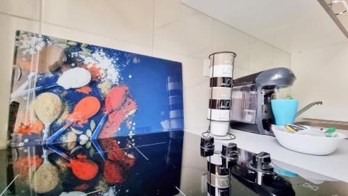 une cuisine avec un tableau mural dans l'établissement La Résidence Évasion 1 - Original - Gare - Wifi - Relax BNB, à Mulhouse