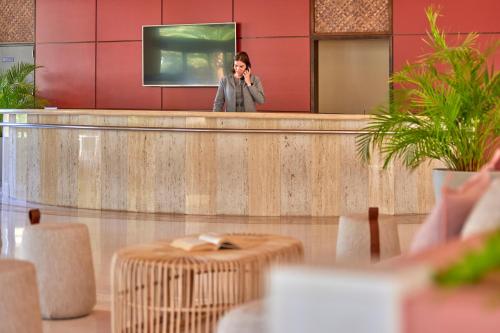 a woman talking on a cell phone in a lobby at Zafiro Mallorca & Spa in Can Picafort