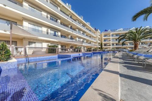 a swimming pool in front of a building at Zafiro Palmanova in Palmanova