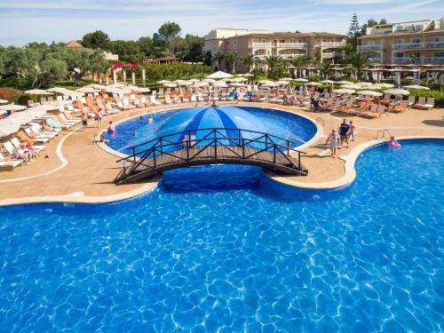 een zwembad in een resort met mensen en parasols bij Zafiro Can Picafort in Can Picafort