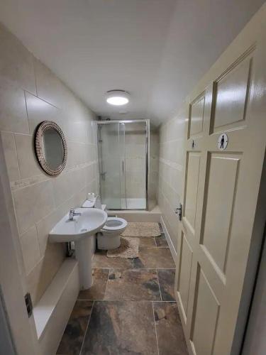 y baño con aseo, lavabo y ducha. en The Dublin Packet - Twin Room, en Holyhead
