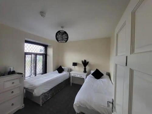 1 dormitorio con 2 camas y reloj en la pared en The Dublin Packet - Twin Room, en Holyhead