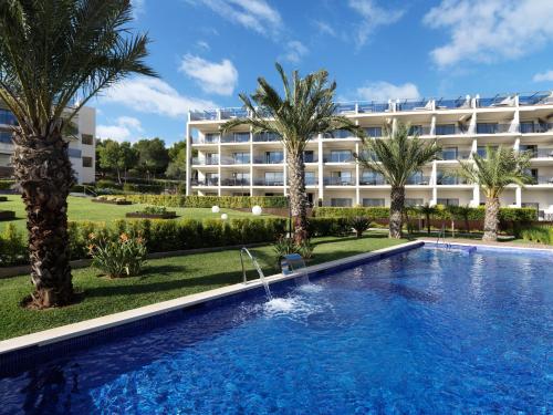 ein Hotel mit einem Pool vor einem Gebäude in der Unterkunft Zafiro Palace Palmanova in Palmanova