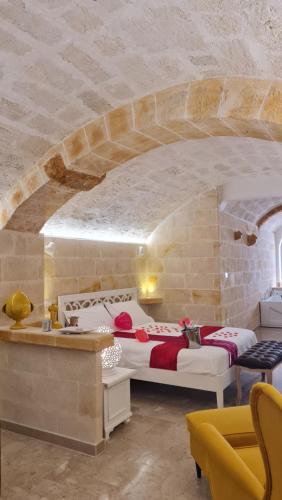 a bedroom with two beds and a stone wall at L'Edicola - SUITE - in Pulsano
