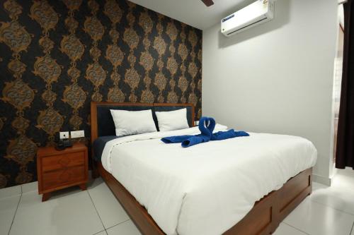 a bedroom with a bed with a blue bow on it at Wayanad Palace in Ambalavayal