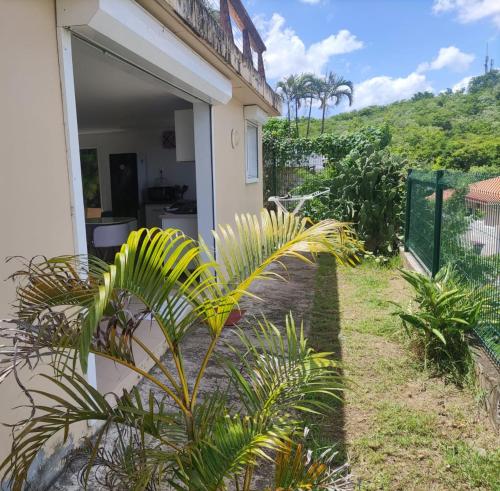 vistas a una casa con plantas en el patio en Kazpucins T2 vue mer et pitons en Les Trois-Îlets