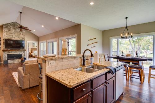 a kitchen with a sink and a living room at Flippin Home with Deck and Grill Steps to White River in Flippin