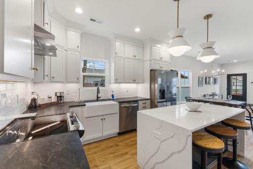 a kitchen with white cabinets and a white counter top at Sunny & modern Derby house in Jeffersonville
