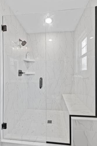a bathroom with a shower with a glass door at Sunny & modern Derby house in Jeffersonville