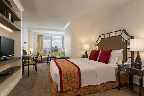 马尼拉Discovery Suites Manila, Philippines的配有床和电视的酒店房间