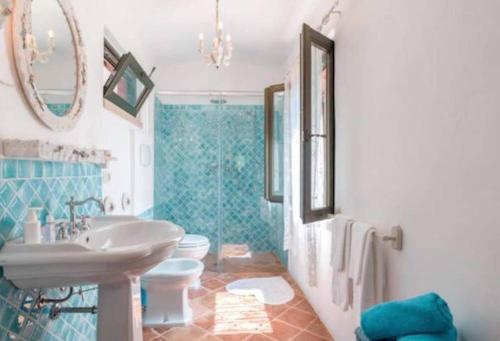 baño azul y blanco con lavabo y aseo en Appartamento in centro storico, en San Giovanni in Marignano