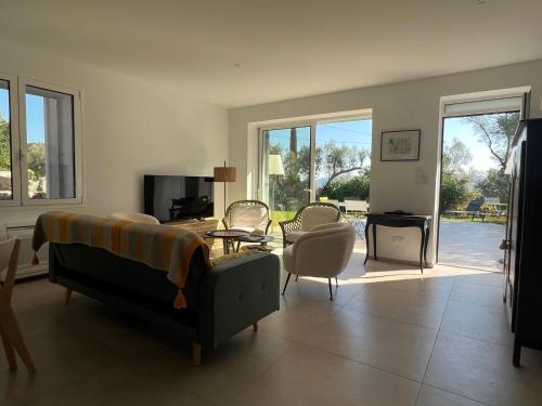 un salon avec un lit, une table et des chaises dans l'établissement Villa les Oliviers, à Porto-Vecchio