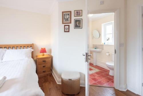 a bedroom with a bed and a bathroom with a toilet at The Little Hopton, Saxmundham in Saxmundham