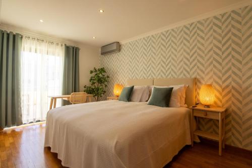 - une chambre avec un lit et deux lampes sur une table dans l'établissement Miradouro da Penha, à Faro
