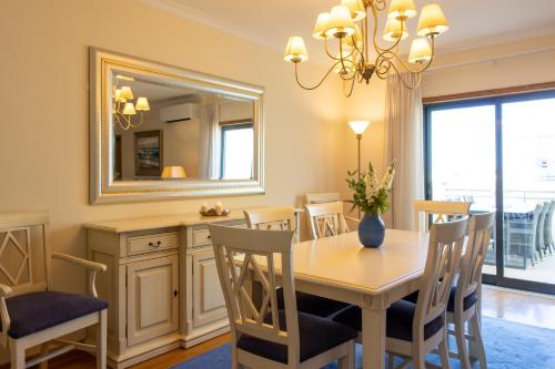 a dining room with a table and chairs and a mirror at Miradouro da Penha in Faro