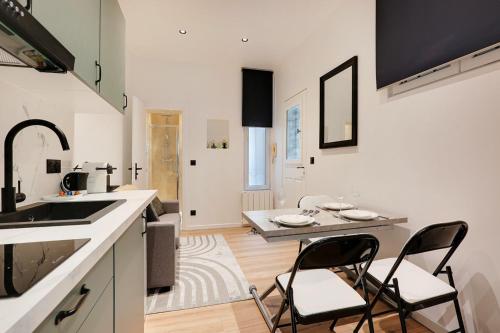 - une cuisine avec deux chaises et une table dans une chambre dans l'établissement Cosy Appartement Portes de Paris, à Aubervilliers