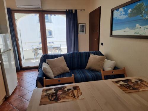 a living room with a blue couch and a table at Le Residenze Blu Sardinia in La Caletta