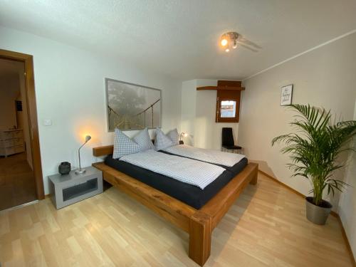 ein Schlafzimmer mit einem Bett und einer Topfpflanze in der Unterkunft Casa al Lag - direkt am Laaxersee in Laax