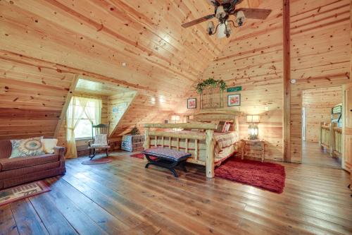 um quarto num chalé de madeira com uma cama e um sofá em Secluded Broken Bow Cabin with Firepit and Deck! em Broken Bow