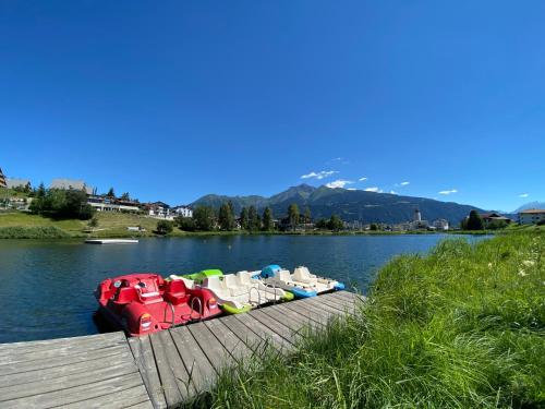 a boat sitting on the water next to a dock at Casa al Lag - direkt am Laaxersee in Laax