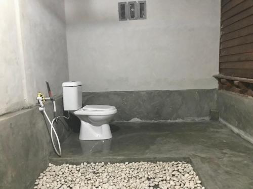 a bathroom with a toilet in a room at Muni's Lombok Bungalow in Masbagik