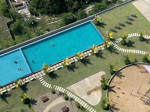 an overhead view of a swimming pool with palm trees at LW Suite at JQ Seaview 2BR High Floor & Wi-Fi in Kota Kinabalu