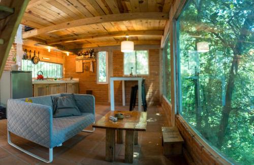 a living room with a couch and a table at The Red Cabin at the bottom of Tepoztlán's Forest in Tepoztlán
