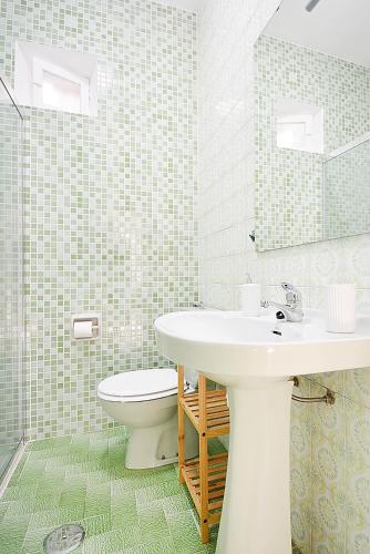 a bathroom with a sink and a toilet and a mirror at GALIHOST - A Casa do Patio in Vilagarcia de Arousa