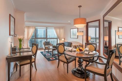 ein Wohnzimmer mit Tisch und Stühlen und einer Couch in der Unterkunft Discovery Suites Manila, Philippines in Manila