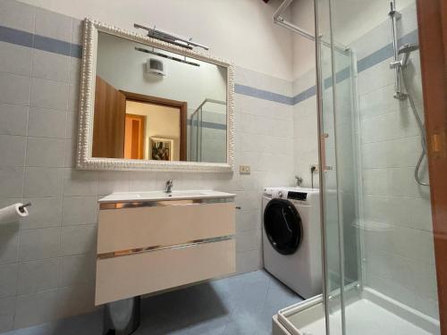 y baño con lavabo, espejo y lavadora. en Appartamento Luce-- 2 camere da letto--Centro storico--Parcheggio privato gratuito, en Lugo