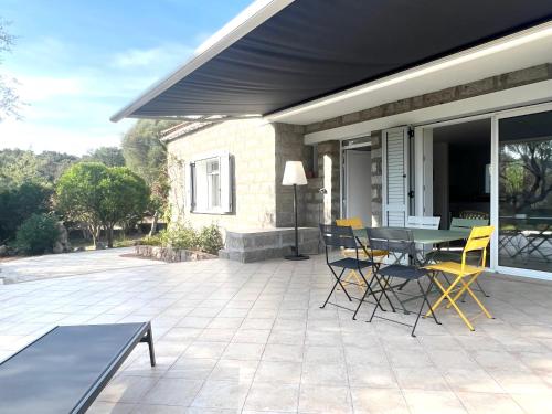 un patio avec une table et des chaises dessus dans l'établissement Villa les Oliviers, à Porto-Vecchio