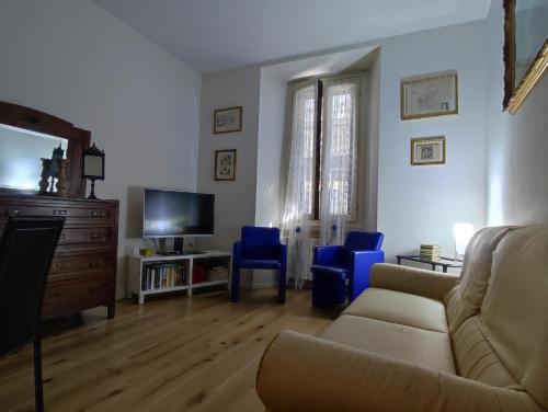 uma sala de estar com um sofá e cadeiras azuis em Appartamento Vitruvio42 em Milão